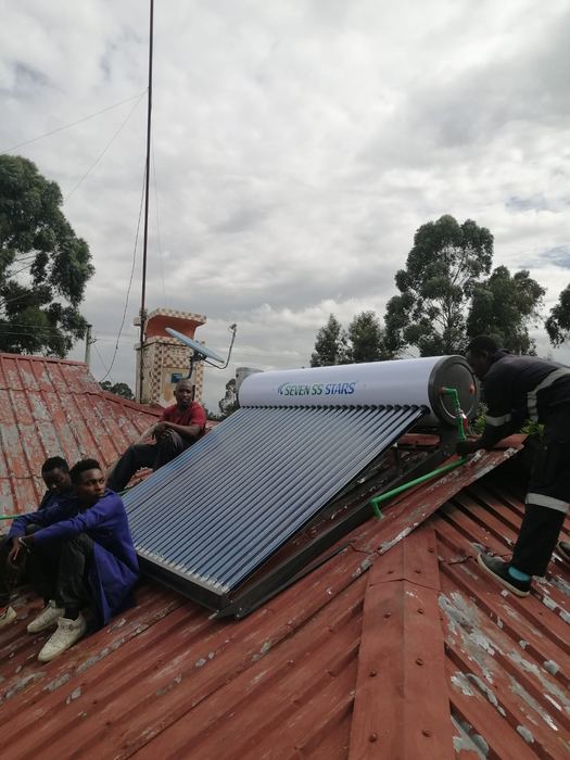 Vegaz technicians fitting a solar water heater on a roof